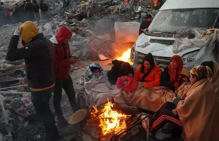 Sobrevivientes de terremoto se reúnen junto a una hoguera en Turquía.
