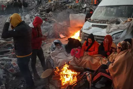Sobrevivientes de terremoto se reúnen junto a una hoguera en Turquía.