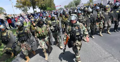 Ciudadanos marchan en Arequipa rodeados por un contingente policial.