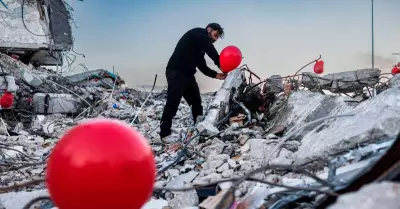 Ogun Sever Okur junto a su asociacin atan globos rojos en los escombros del ter