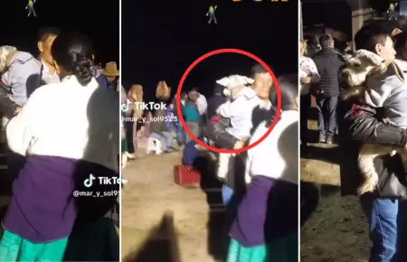 Hombre baila con su perro en brazos en fiesta patronal