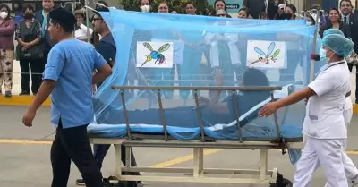 Enfermeros participan en un desfile con paciente de dengue.