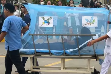 Enfermeros participan en un desfile con paciente de dengue.
