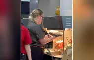 Trabajadora de conocida cadena de comida rpida seca trapeador en calentador de papas fritas