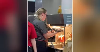 Trabajadora de McDonald's seca trapeador en calentador de papas fritas