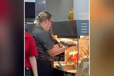 Trabajadora de McDonald's seca trapeador en calentador de papas fritas