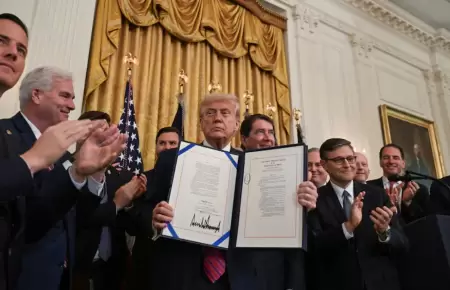 Donald Trump con el documento que cuenta con su firma.