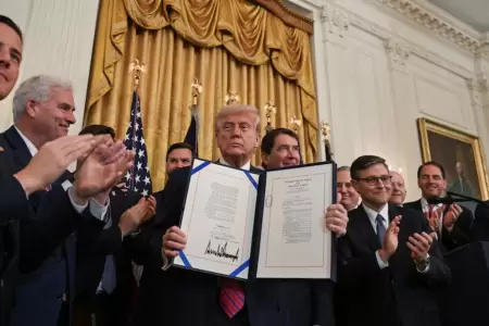 Donald Trump con el documento que cuenta con su firma.