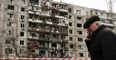 Hombre frente a edificio destruido en Ucrania