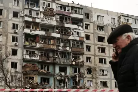 Hombre frente a edificio destruido en Ucrania