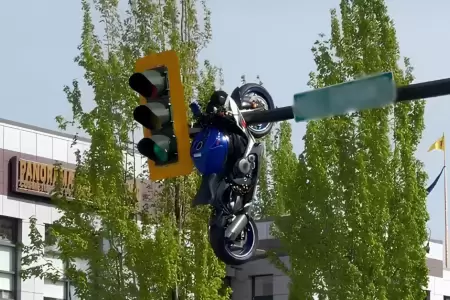Motocicleta queda colgada de un sem�foro